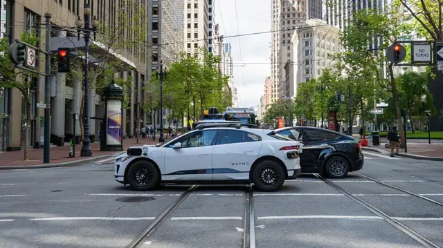 Véhicule électrique autonome Waymo sur Market Street, entre les tours de bureaux du centre-ville de San Francisco, en Californie, le 13 mai 2025.
