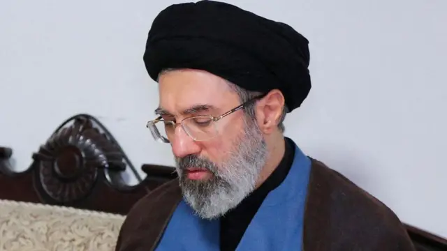 Mojtaba Khamenei, coiffé d'un turban noir et portant des lunettes, est photographié lors d'une visite au bureau du Hezbollah à Téhéran en 2024.
